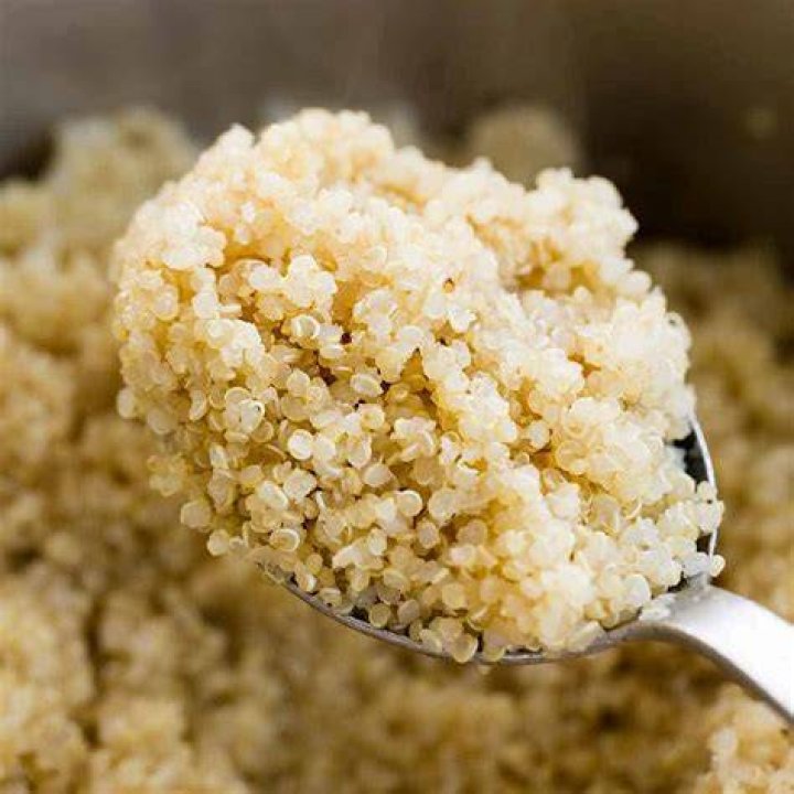 Cooked quinoa in a cast iron pan on rustic wooden table. cooked quinoa in a cast iron pan on rustic wooden table