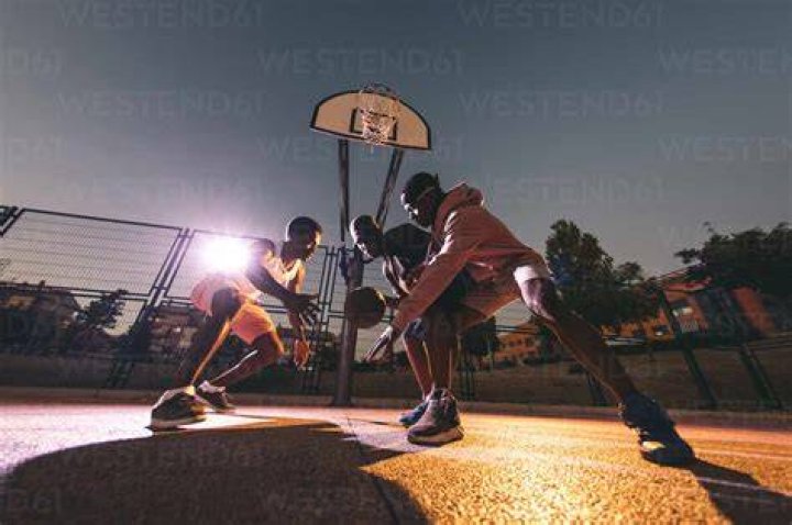 friends playing basketball in a school gym