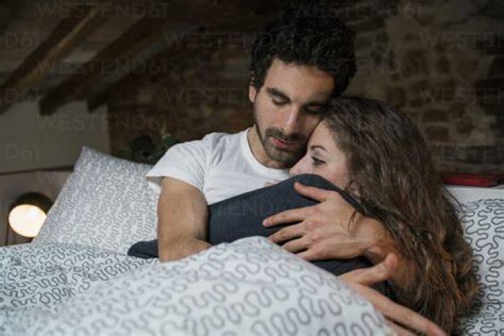 intimate couple laying on bed