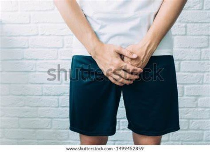 man wearing shorts holding genitals men's health, venereologist, sexual disease
