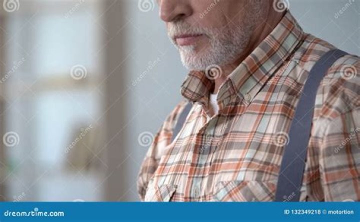 Old man in checkered shirt holding a photo camera at Torgayti Village