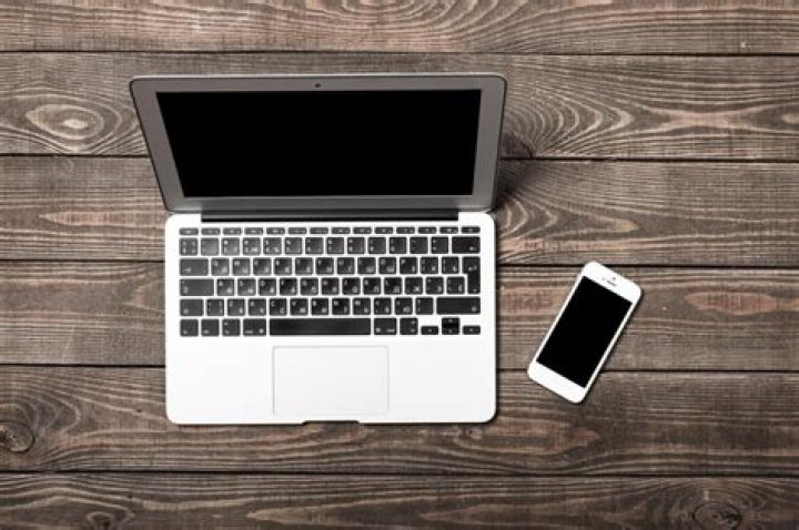 open laptop on a wooden desk displaying a resume sample