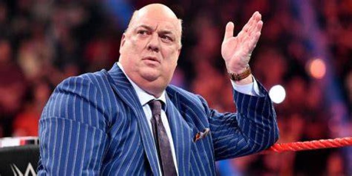 Paul Heyman walking down to the ring next to Roman Reigns.