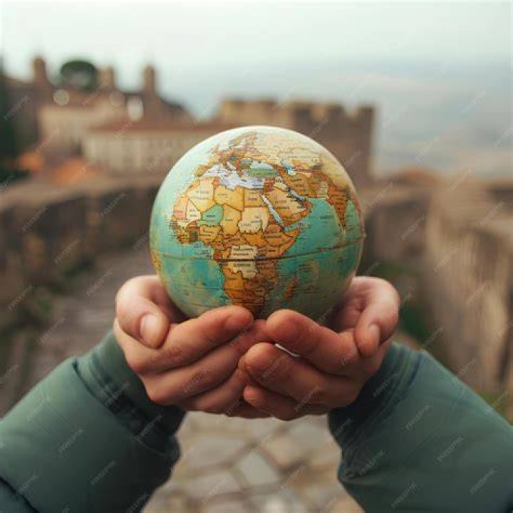 person holding small globe
