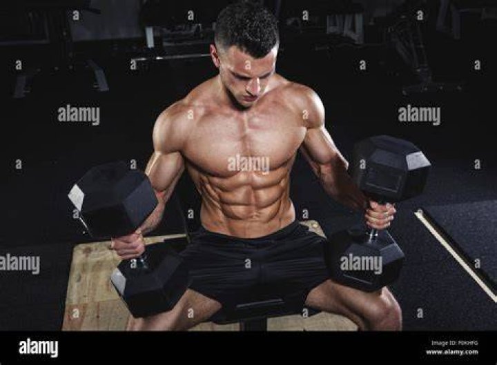 physical athlete doing dumbbell bench presses