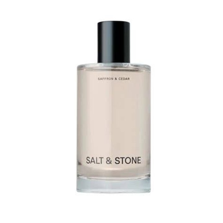 salt and stone saffron and cedar long-lasting candle on a light gray background