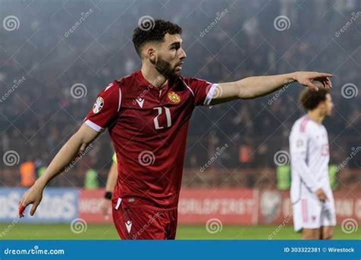 Soccer player pointing excitedly and high-fiving teammate