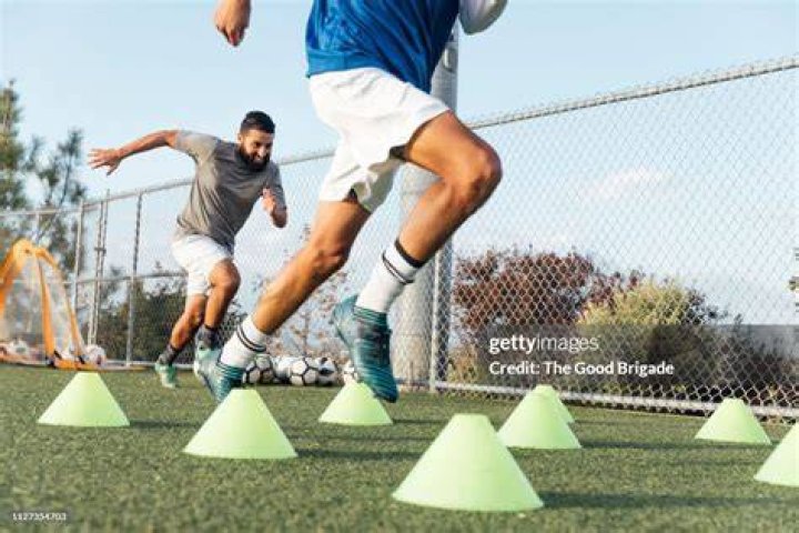 soccer players performing warm up drills on field