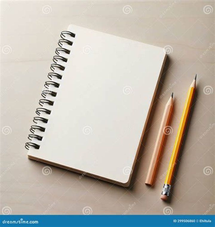 two pencils and a notebook on a tabletop