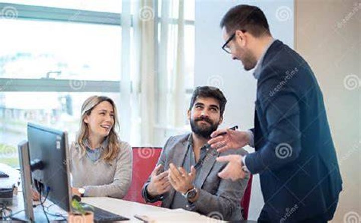 two professionals speaking during an interview next to a bright window