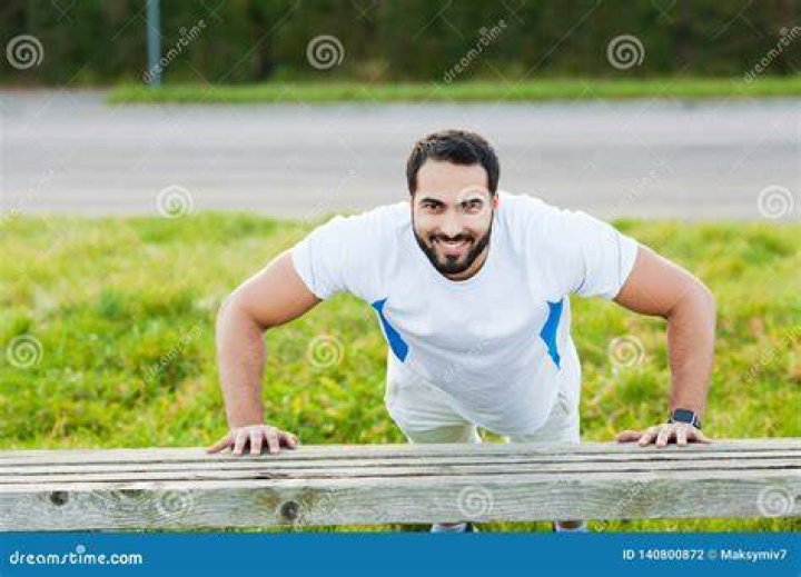 Young sporty man training on treadmill in modern gym, closeup